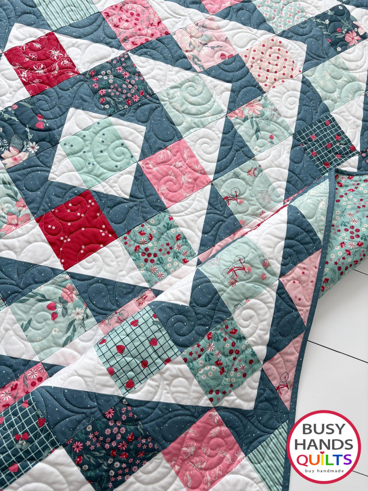 Handmade, heirloom-quality throw quilt in Skip to My Lou quilt design in pink, red, and teal florals. Perfect Christmas present idea, or birthday gift idea for women or young girl.