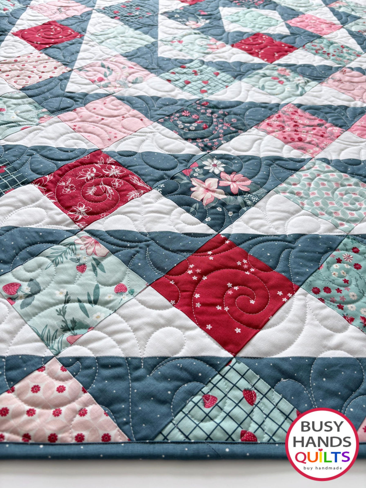 Handmade, heirloom-quality throw quilt in Skip to My Lou quilt design in pink, red, and teal florals. Perfect Christmas present idea, or birthday gift idea for women or young girl.
